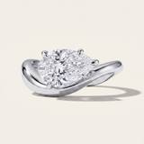 MOHSTEN Venice pear diamond solitaire engagement ring in polished platinum showcasing a face-on studio view of the east-west oriented pear-cut diamond on a fluid, sweeping curved band casting a distinct architectural shadow.