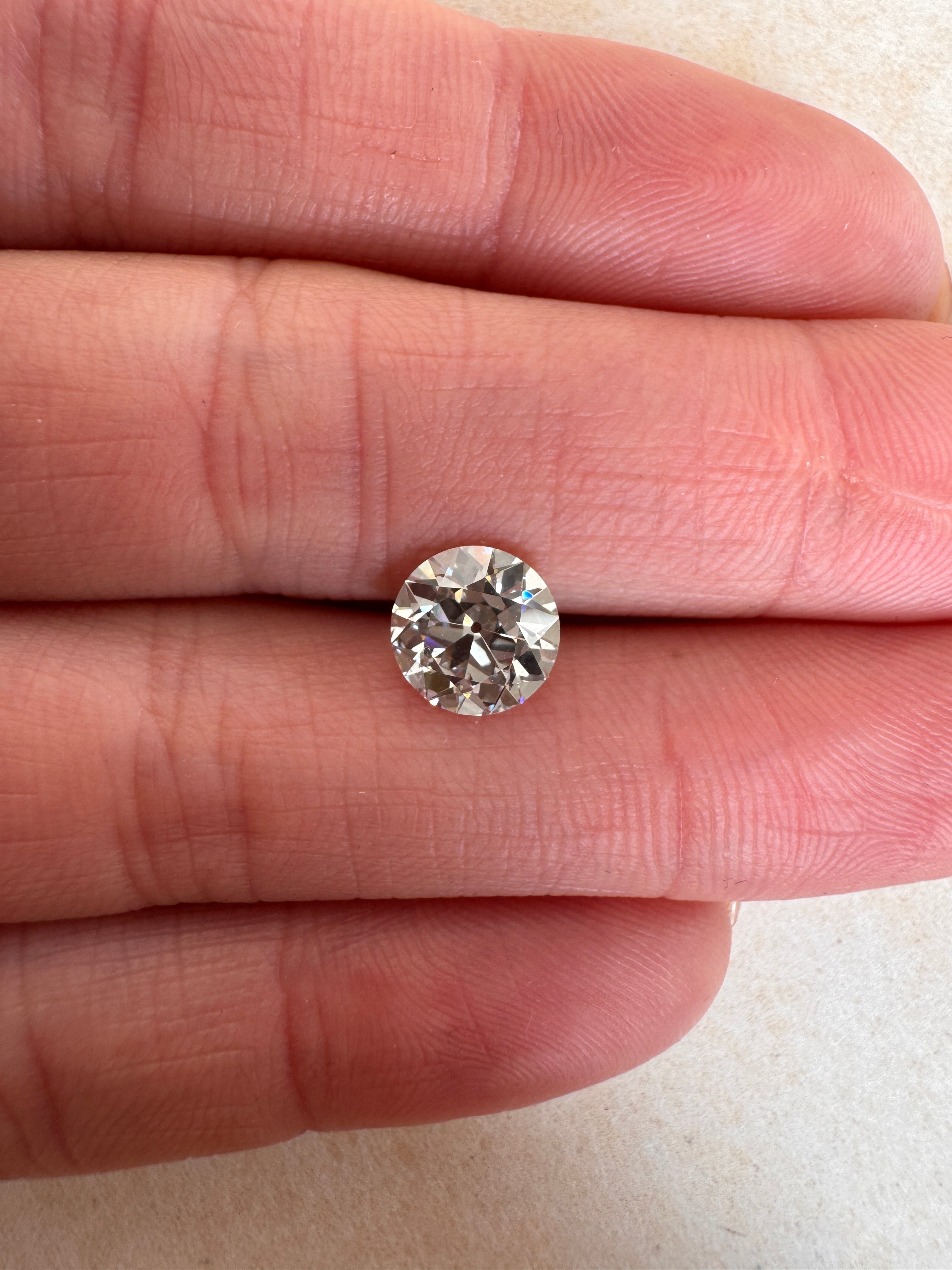 A loose 1.52ct Old European cut lab-grown diamond resting on fingers to demonstrate its scale. Sourced for bespoke custom engagement rings by MOHSTEN jewellery studio in Auckland, New Zealand.