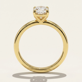 Side profile through-finger view of the MOHSTEN Osaka oval diamond solitaire engagement ring in 18ct yellow gold, highlighting the circular band profile and the minimalist signature 4-prong basket setting casting a shadow.