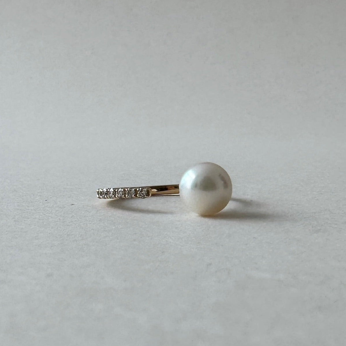 Pearl earring on a light gray background