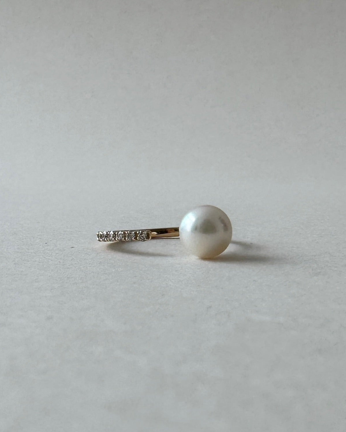 Pearl earring on a light gray background