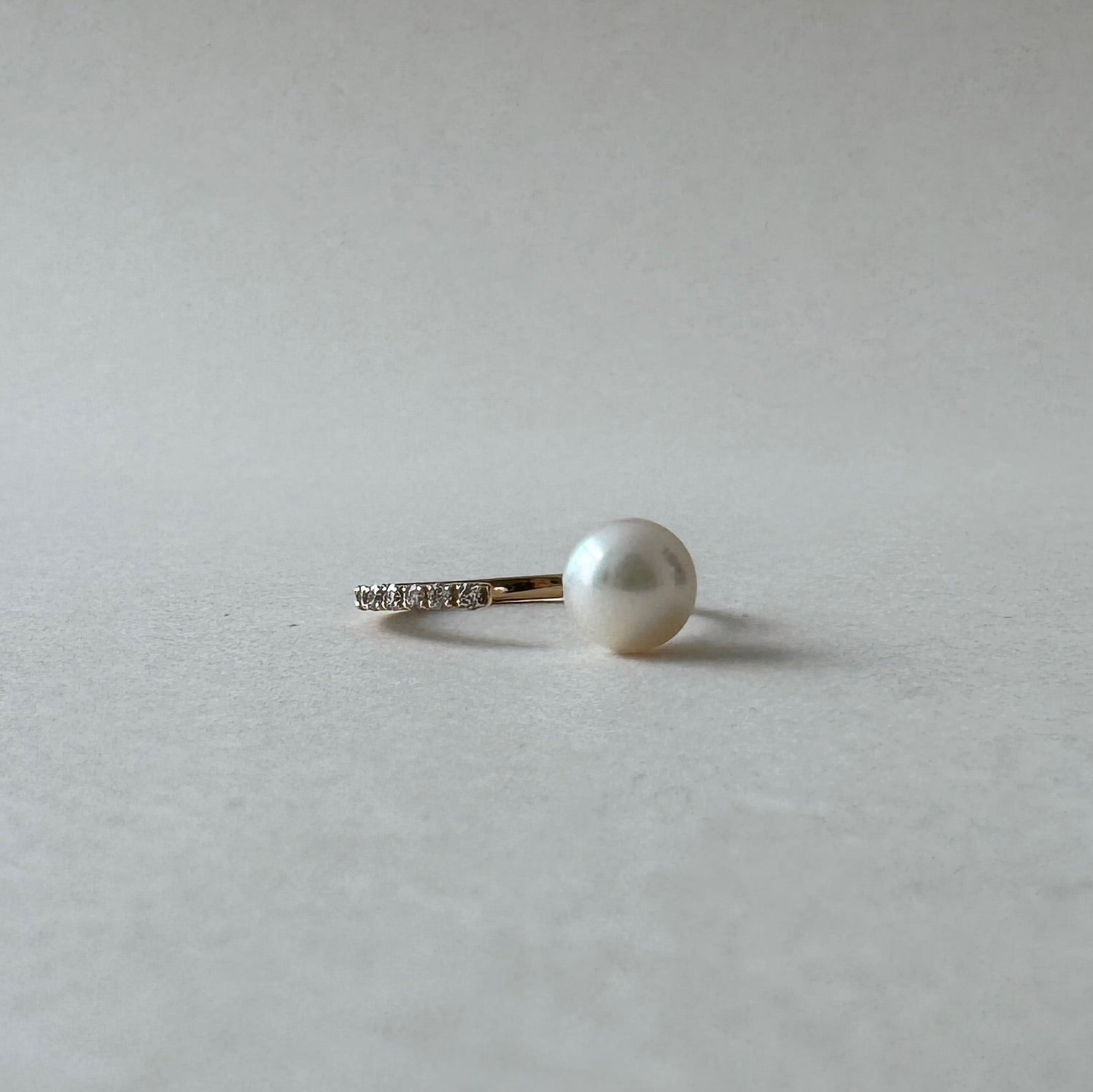 Pearl earring on a light gray background
