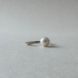 Pearl earring on a light gray background