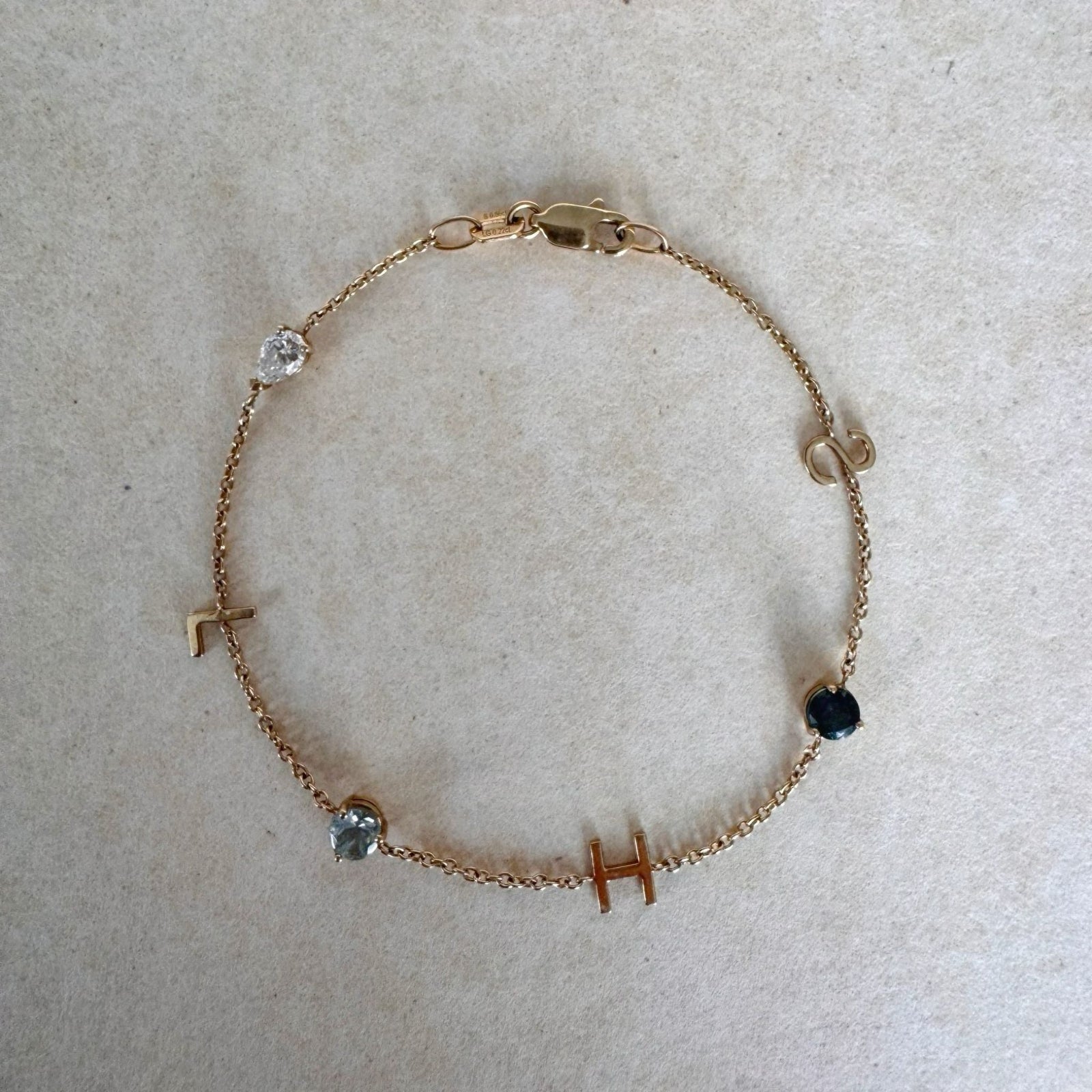 Gold bracelet with small gemstones on a light gray background