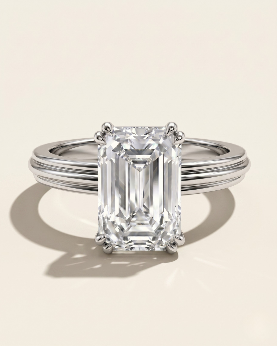 MOHSTEN Brooklyn emerald cut diamond engagement ring in polished platinum displaying the double-claw basket setting and textured band architecture.