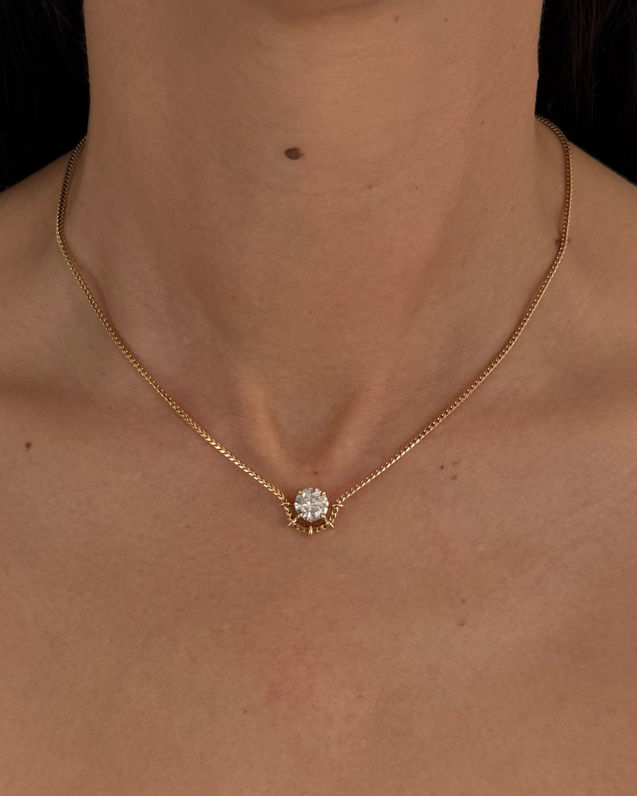 Woman wearing the MOHSTEN Solaris Diamond Pendant Necklace in 9ct yellow gold, featuring a round brilliant cut solitaire diamond in a refined cage setting.