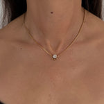 MOHSTEN Solaris Diamond Pendant Necklace in gold, featuring a single round brilliant cut diamond on a fine chain, modelled on a woman's neck.