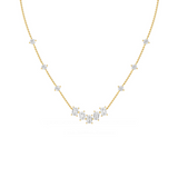 A gold necklace featuring a series of round and emerald cut diamonds.
