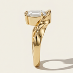 Side profile view of the MOHSTEN Tairua oval diamond solitaire engagement ring in 18ct yellow gold showcasing the heavy, sculptural curves of the architectural bypass ribbon band.