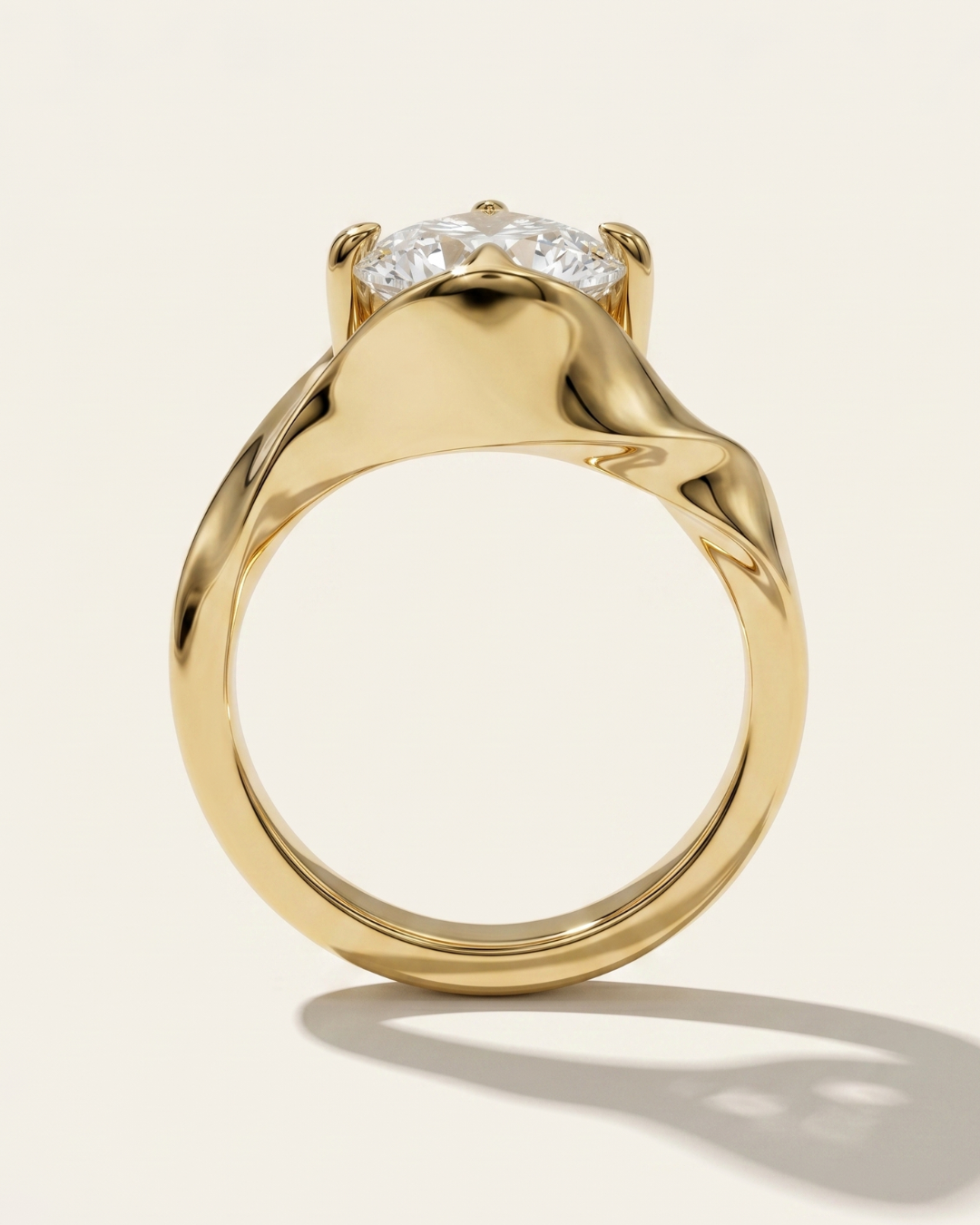 Through-finger profile view of the MOHSTEN Tairua oval diamond solitaire engagement ring in 18ct yellow gold highlighting the sculptural, fluid lines of the architectural bypass band.