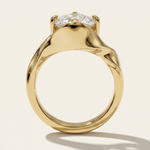 Through-finger profile view of the MOHSTEN Tairua oval diamond solitaire engagement ring in 18ct yellow gold highlighting the sculptural, fluid lines of the architectural bypass band.