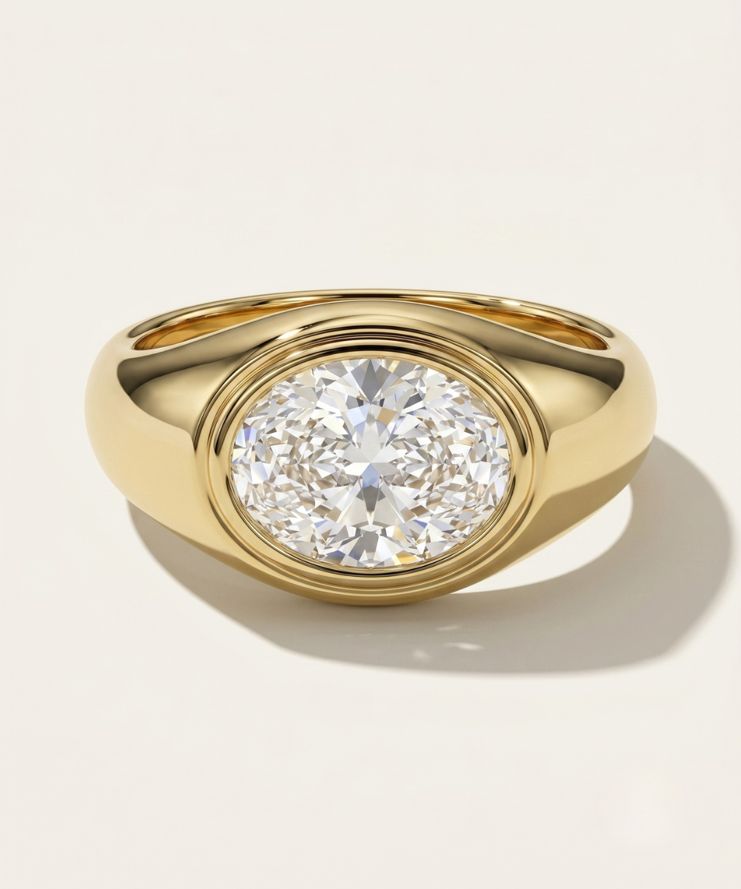 MOHSTEN Tova modern dome signet ring with bezel set oval diamond in yellow gold.