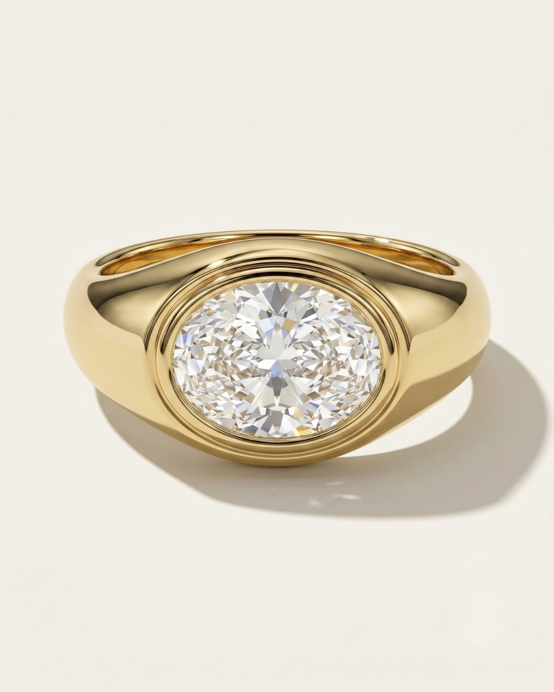 MOHSTEN Tova modern dome signet ring with bezel set oval diamond in yellow gold.