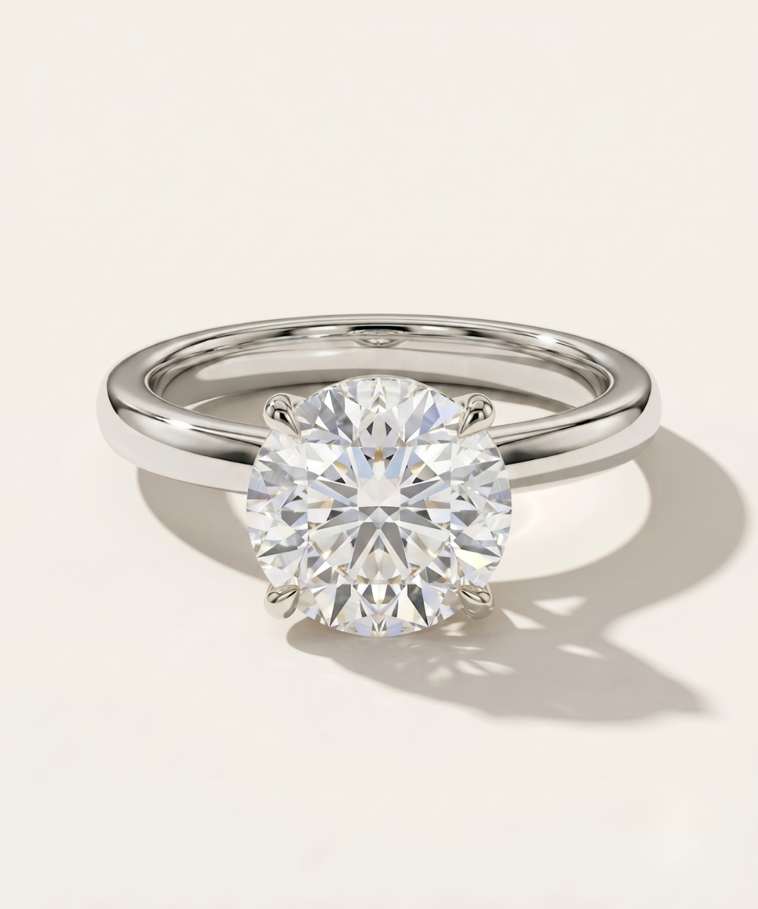 MOHSTEN Uluwatu round diamond solitaire engagement ring in polished platinum displaying a premium round brilliant centre stone in a minimalist 4-prong setting.