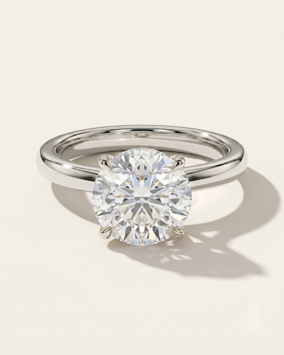 MOHSTEN Uluwatu round diamond solitaire engagement ring in polished platinum displaying a premium round brilliant centre stone in a minimalist 4-prong setting.