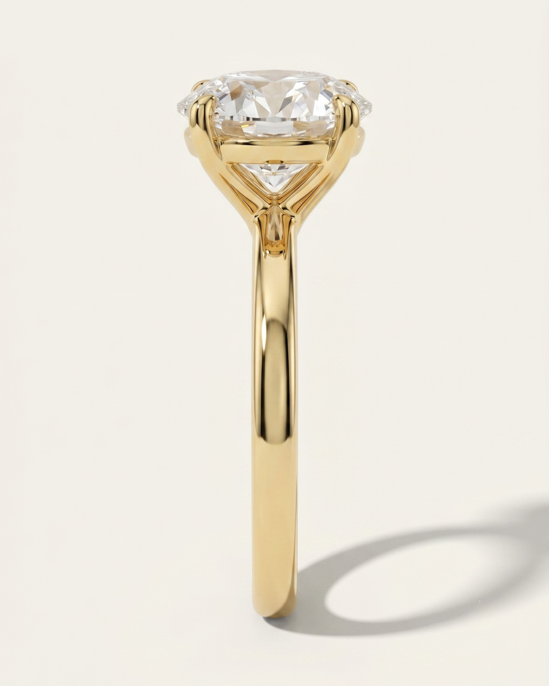End profile view of the MOHSTEN Uluwatu round diamond solitaire engagement ring in 18ct yellow gold showcasing the fluid lines of the comfort-fit band and the geometric 4-prong basket setting.