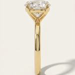 End profile view of the MOHSTEN Uluwatu round diamond solitaire engagement ring in 18ct yellow gold showcasing the fluid lines of the comfort-fit band and the geometric 4-prong basket setting.