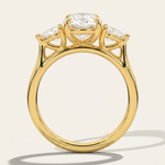 Through-finger architectural view of the MOHSTEN Valencia oval and pear diamond trilogy engagement ring in 18ct yellow gold highlighting the low-profile gallery setting.