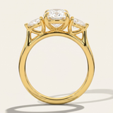 Through-finger architectural view of the MOHSTEN Valencia oval and pear diamond trilogy engagement ring in 18ct yellow gold highlighting the low-profile gallery setting.