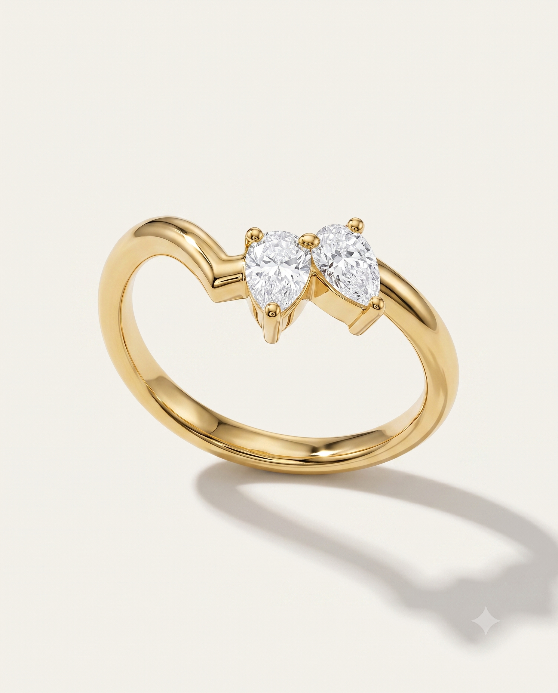 a yellow gold wishbone ring with asymmetric pear diamonds